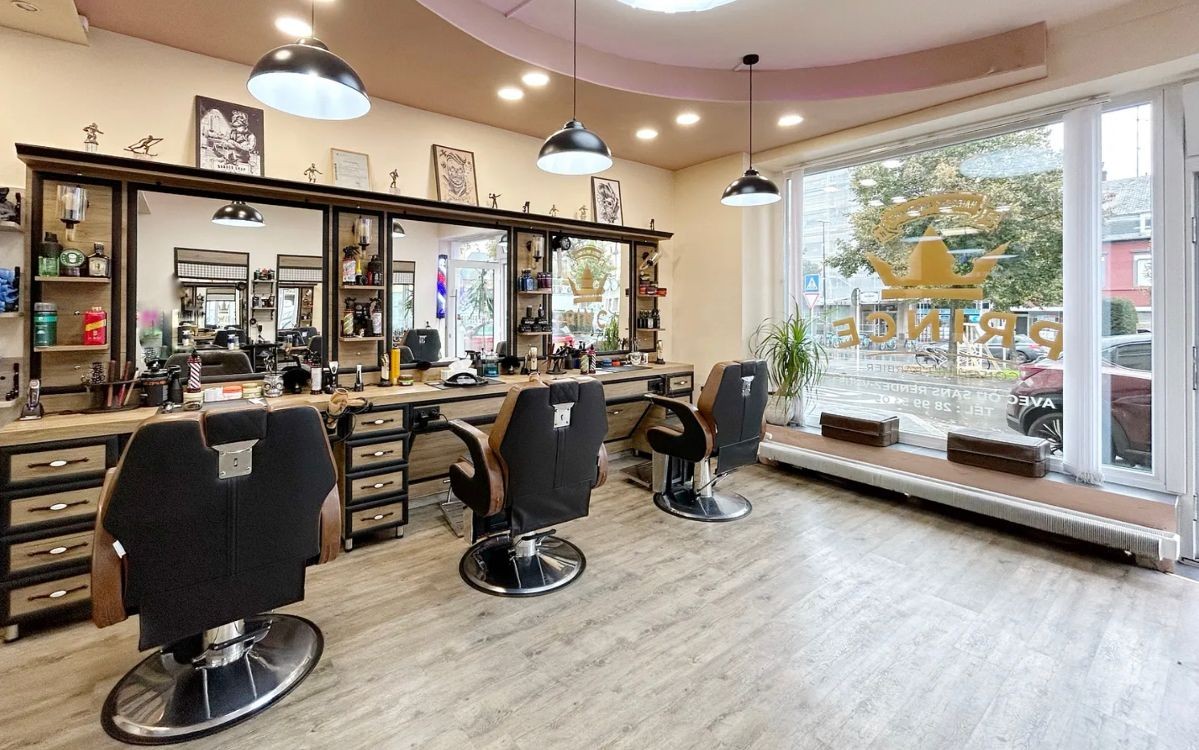 Modern barbershop interior with multiple chairs, mirrors, and grooming products.